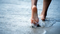 Woman Bare Foot Walking On The Summer Beach.